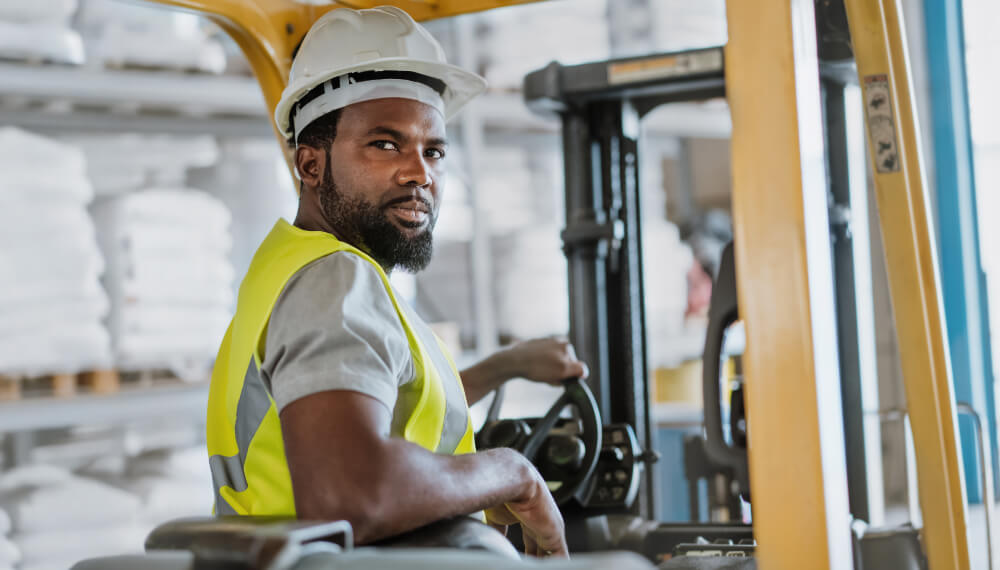 Factory worker driving a forklift inside a factory