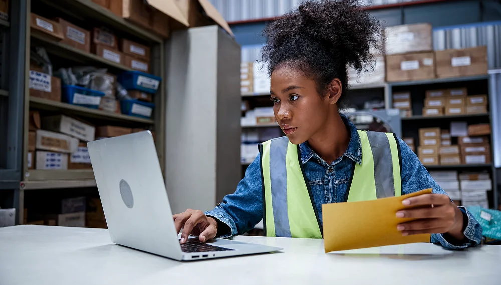 Woman using a laptop at warehouse