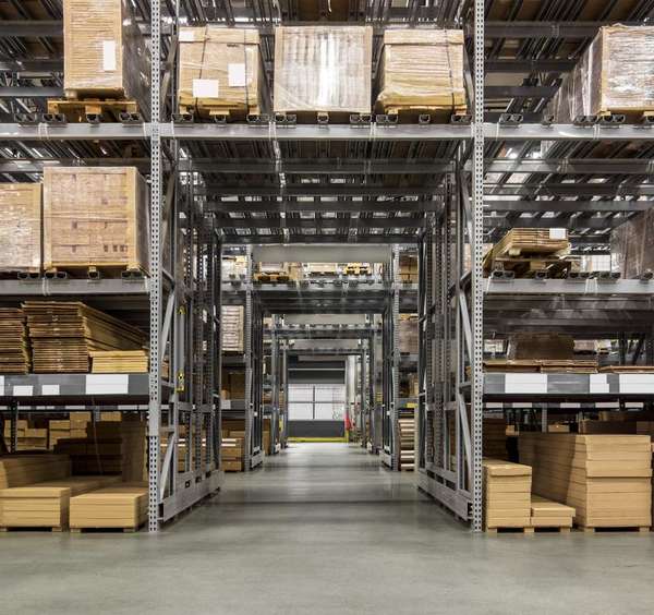 Pracovník velkoobchodní distribuce používá systémy pro řízení distribuce k navádění ve skladu a plnění objednávek