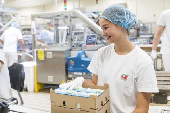 photo of smiling food factory worker packaging products