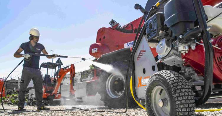guy in a hardhat power washing a work truck