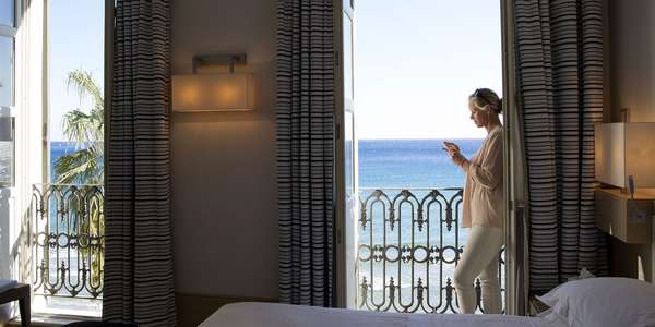 woman relaxes in hotel room with a beach view