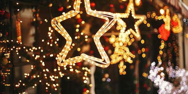 christmas golden star illumination fir
  branches with red gold baubles lights bokeh Comms AdobeStock 