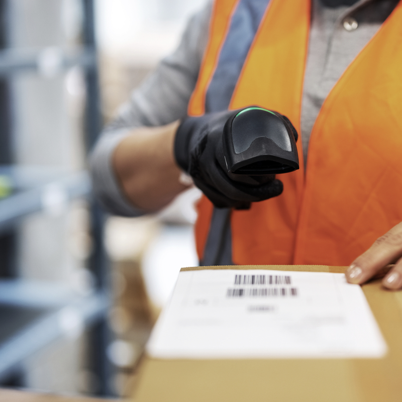 woman warehouse worker scanning package with bar code scanner