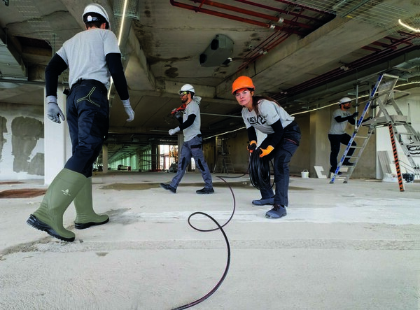 male female workers safety gear electrical wire building site