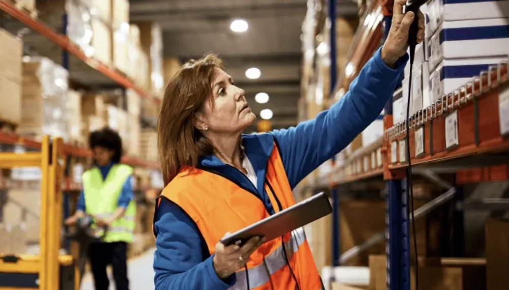Woman in warehouse scanning boxes