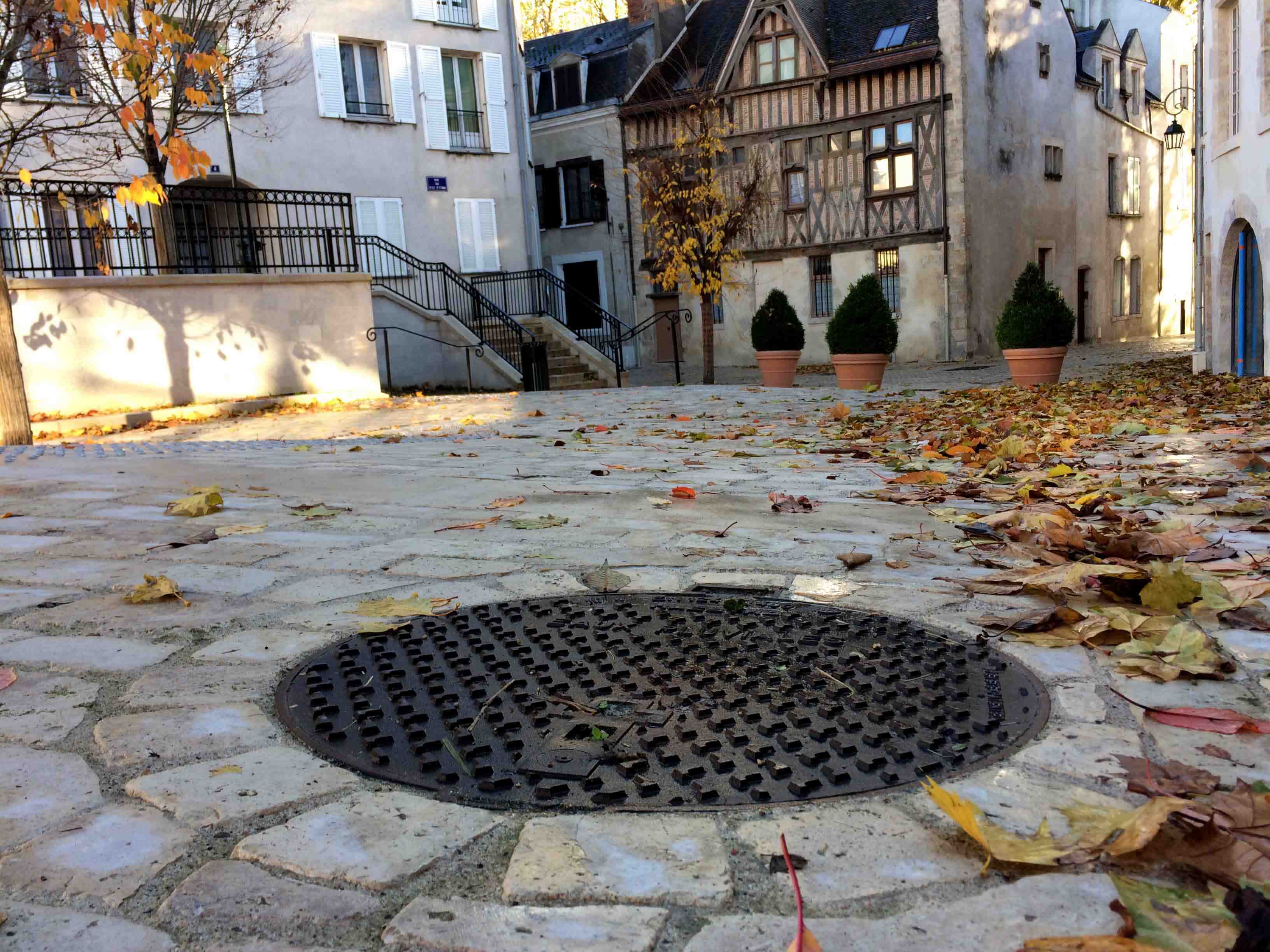 grate on stone ground leading to city underground