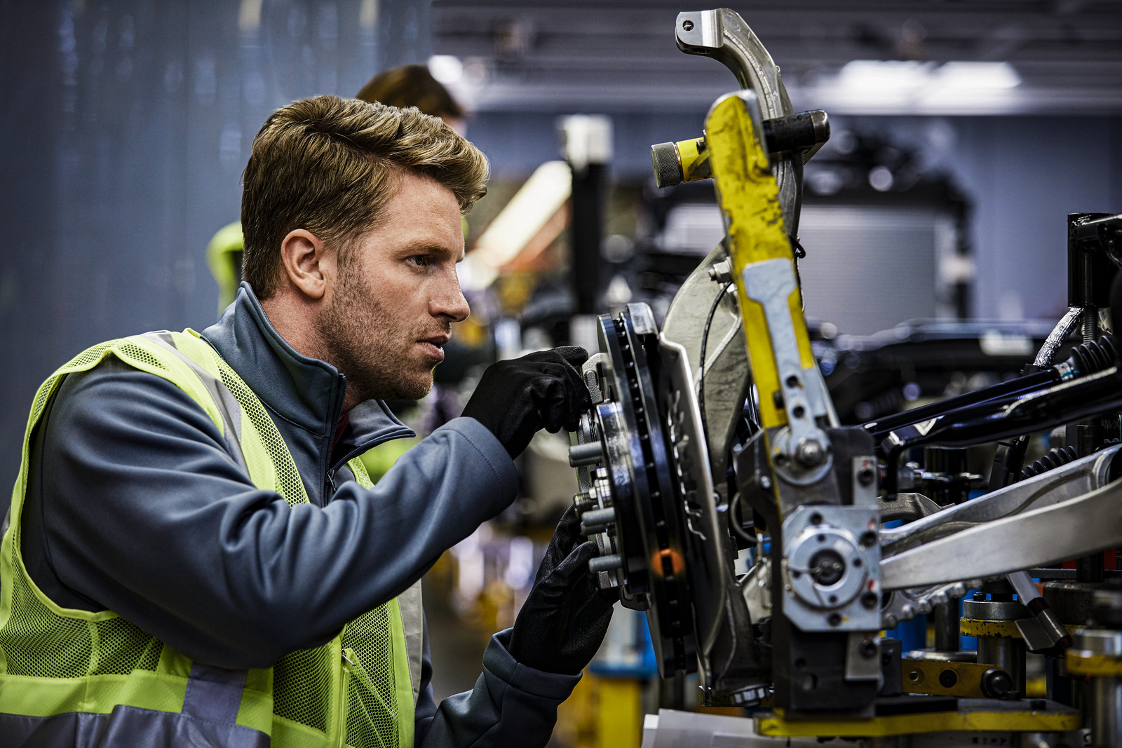 Engineer examining car chassis at automobile industry