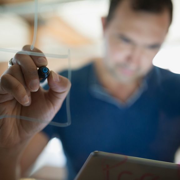 IT manager mapping out an automated task on a glass dry erase board 