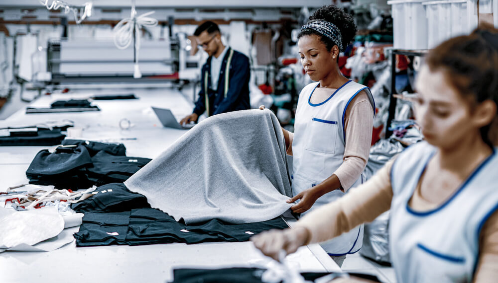 Two female employees working in a textile factory looking at fabric