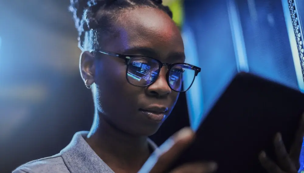 Female engineer using a digital tablet while working in a server room