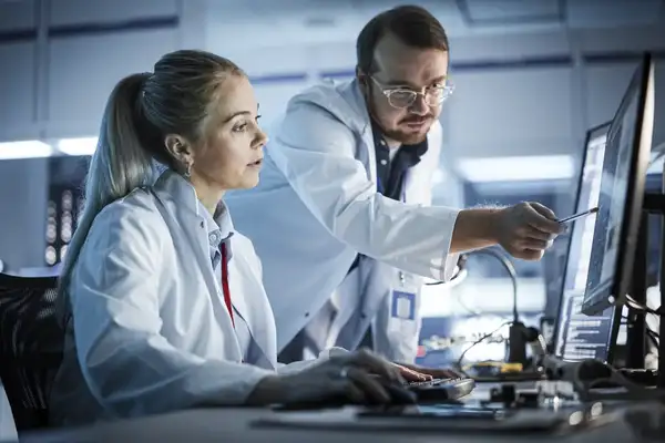 Project manager talks with scientist working on a computer