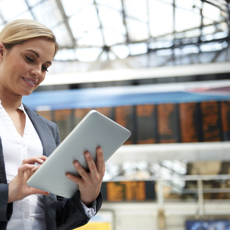 Female Using tablet computer under electronic timetable