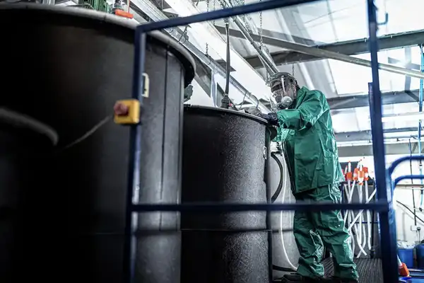 Worker mixing tanks in a chemical factory