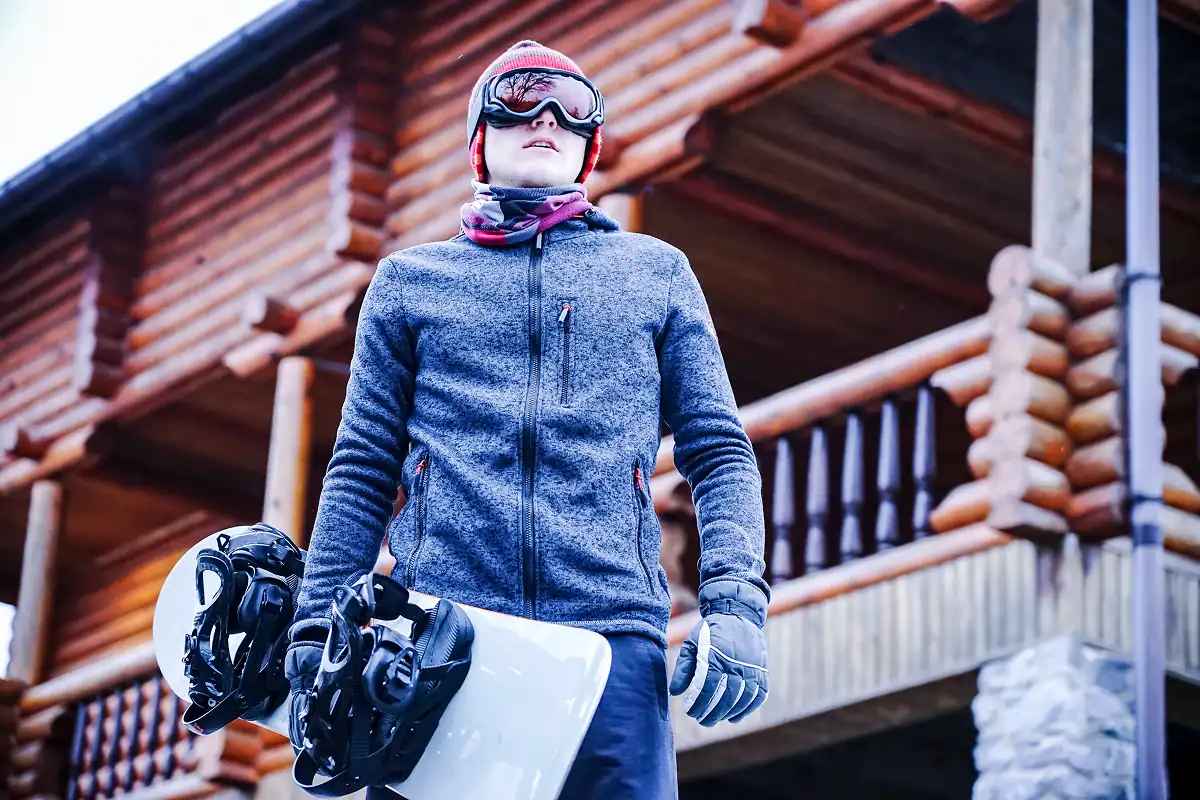 Snowboarder in front of an alpine lodge