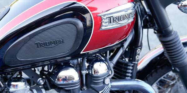 369891302_triumph-vintage-logo-sign-and-text-on-motorcycle-detail-on-red-fuel-tank