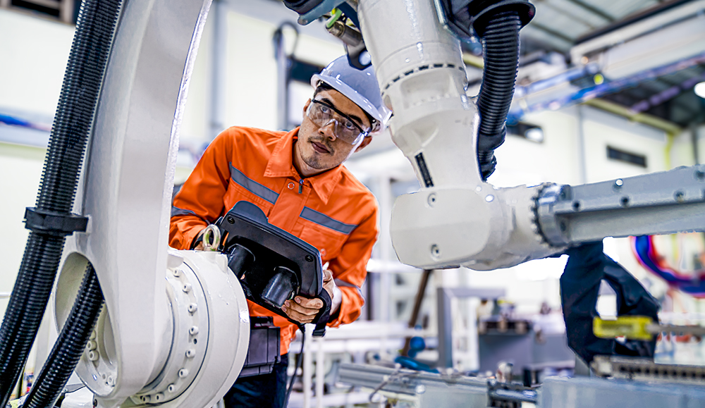 The professional officer checks the robot moving on the jig base in a manufacturing factory