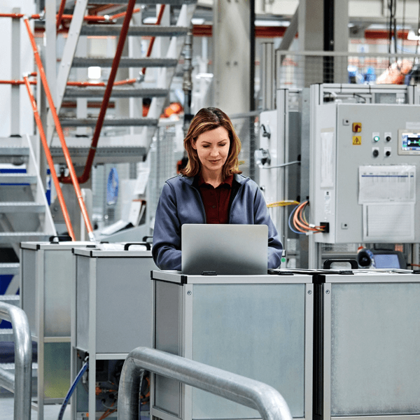 A female engineer finalizing plans for a production line on her laptop