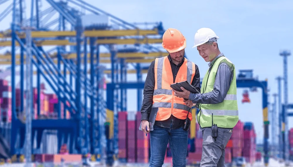 Dock workers using control tower software on a tablet