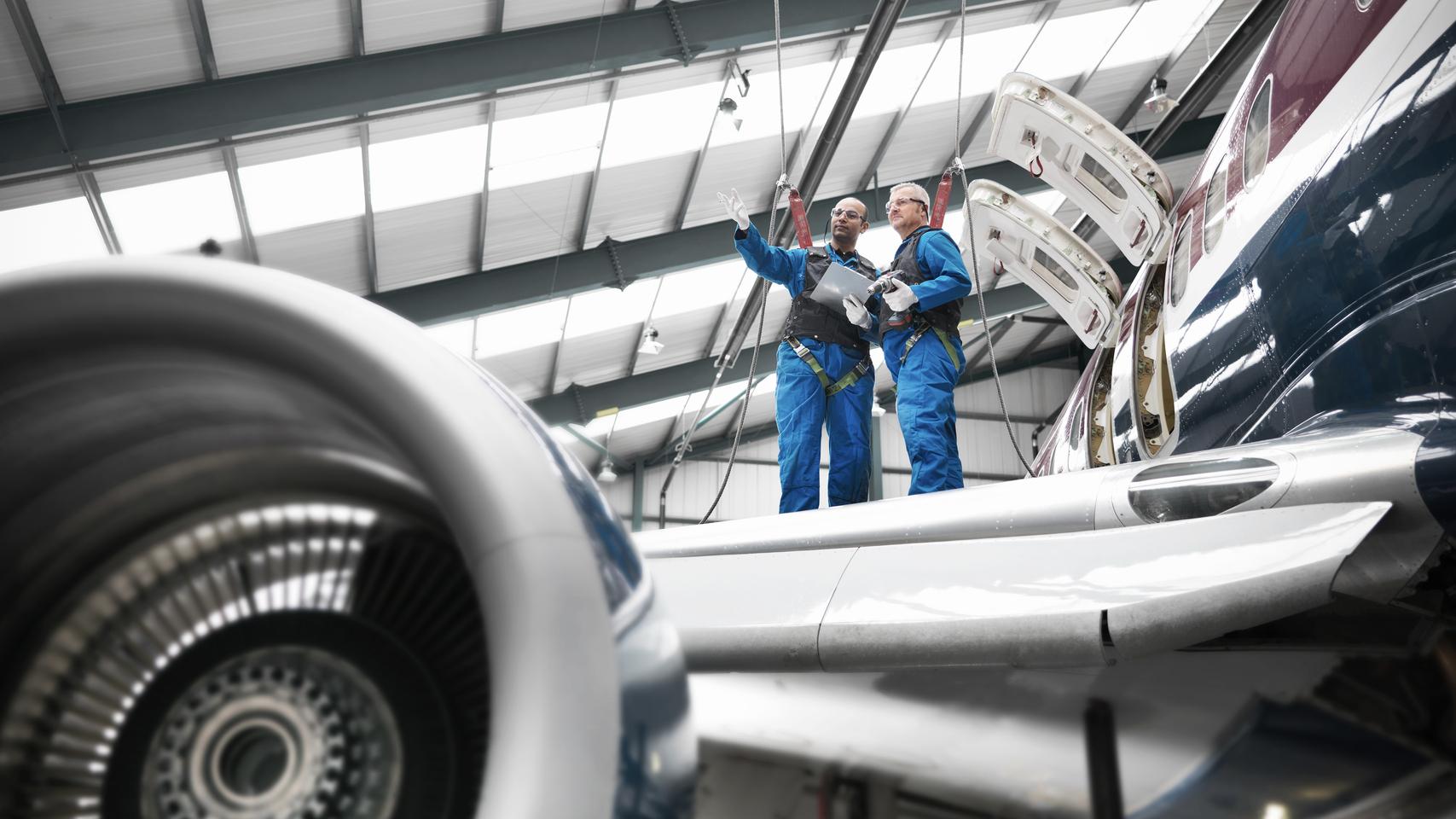 Technicians standing on the wing of an aeroplane 