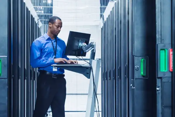 Businessman standing at his rising desk in a cloud server room