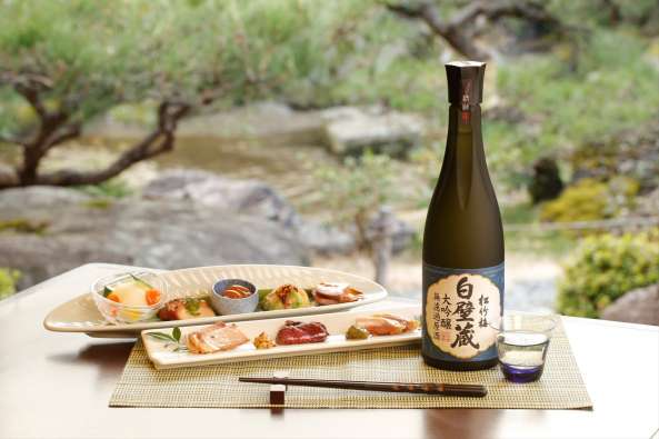 sake bottle and sushi meal on a place setting on an outside table