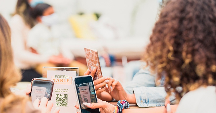 Women mobile phones restaurant POS QR code scan