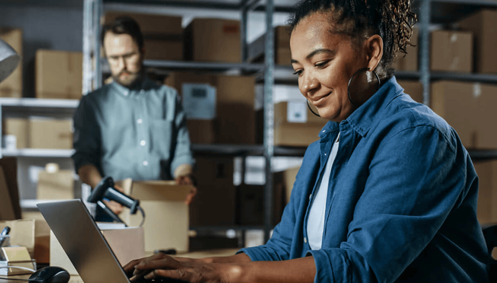 Warehouse manager using cloud ERP software on a laptop