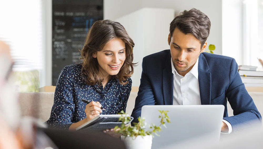 Colleagues reviewing certification programs on a laptop 