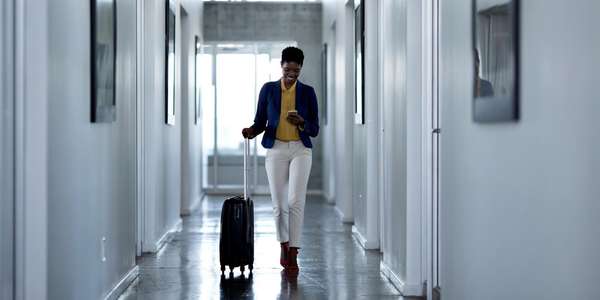 683980938 hsp woman walking down hall suitcase mobile phone 2023 03 27 164135 ltzp