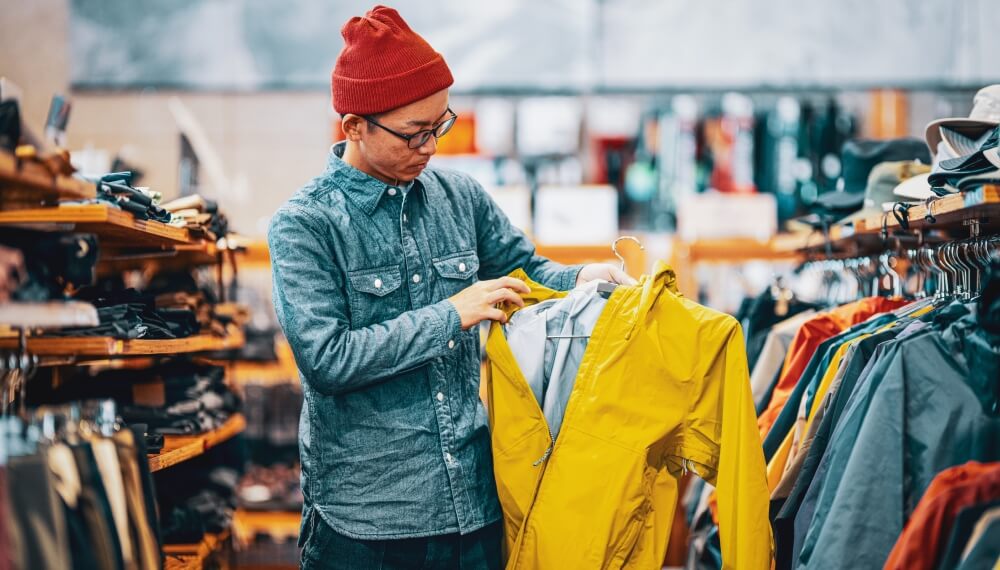 Retail staff hanging items in a clothing store