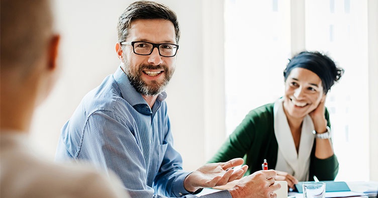 Three smiling people at business meeting