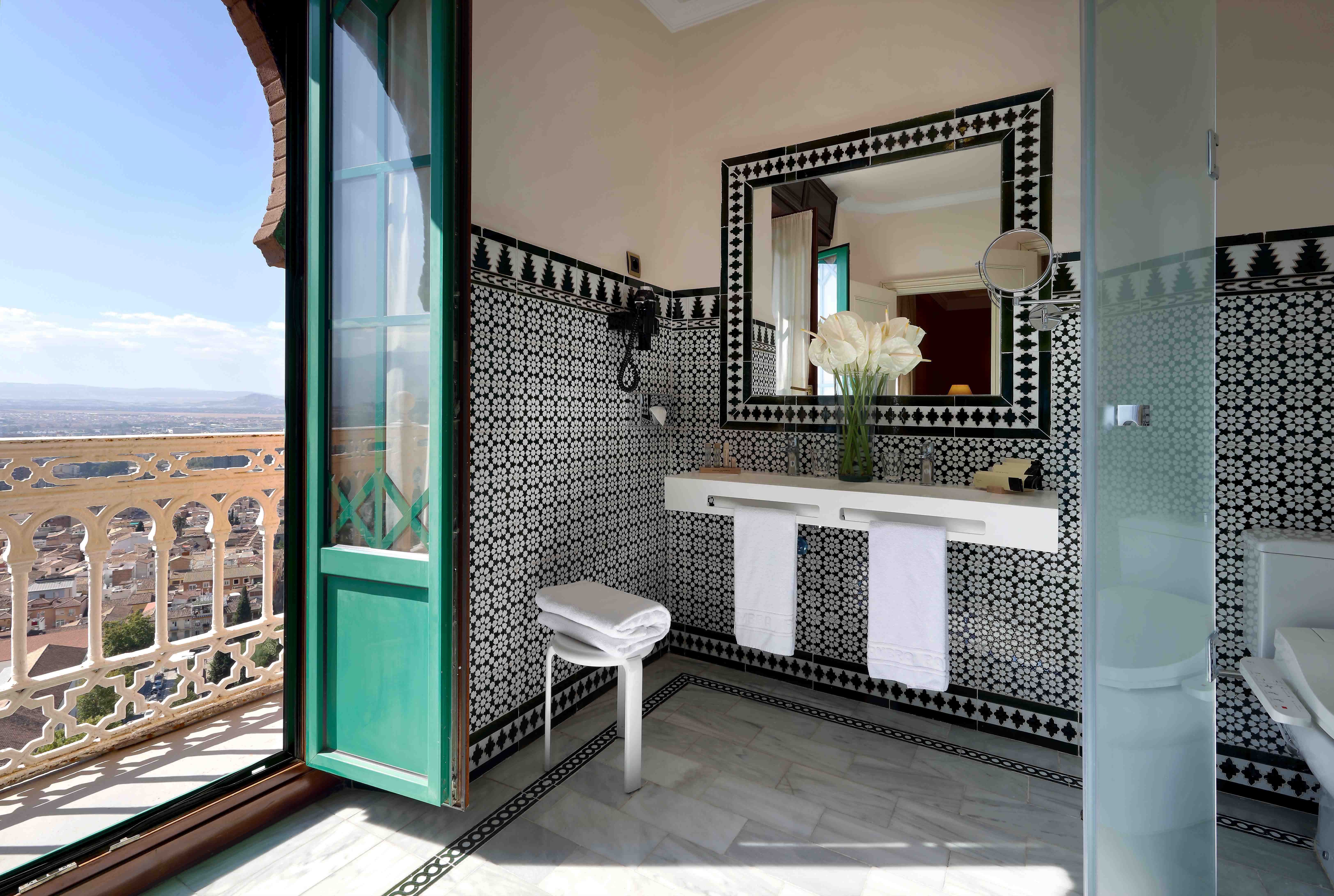 a bathroom with a view at the hotel alhambra with black and white tiles