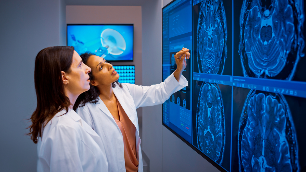 Medical research staff in lab coats reviewing clinical data