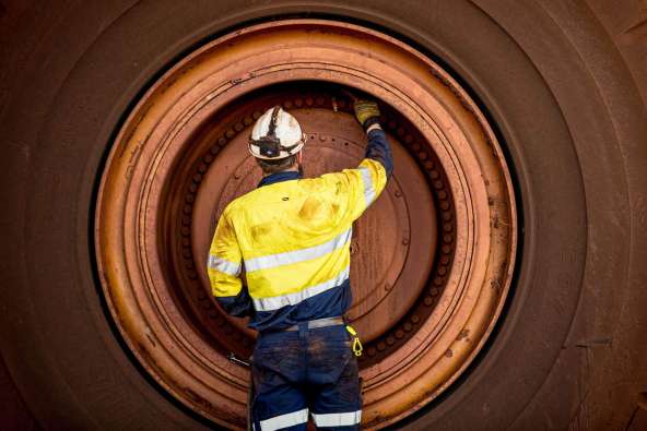 man working on a large tractor tire