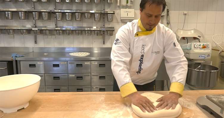 man kneading dough in kitchen