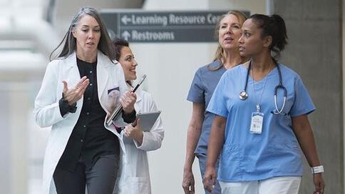 Male and female doctors walking in hospital hallway