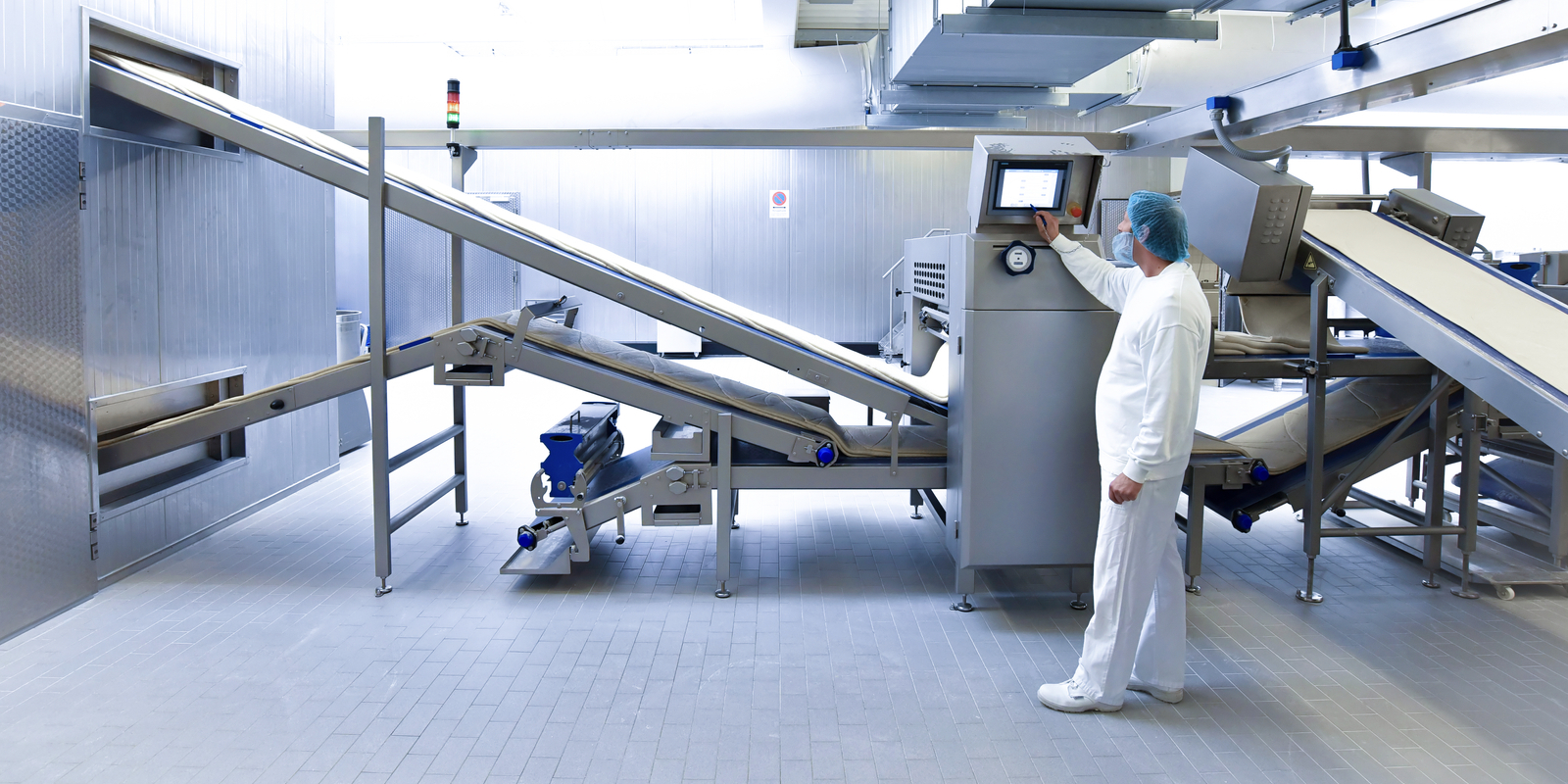 Worker operating a machine in an industrial bakery