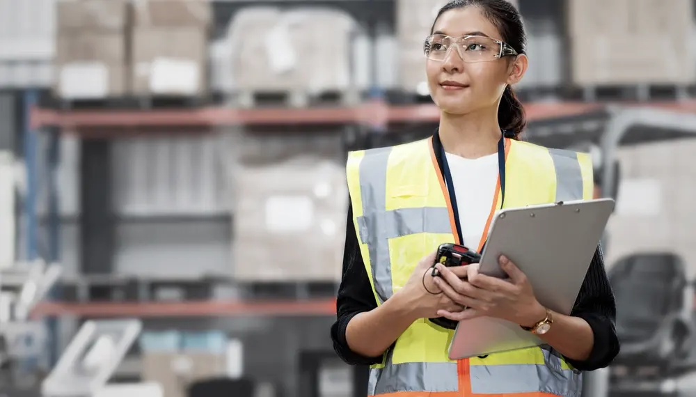 Smiling warehouse manager standing in a aisle