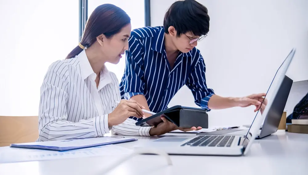 Supply chain planning team reviewing a network operations dashboard in a modern office