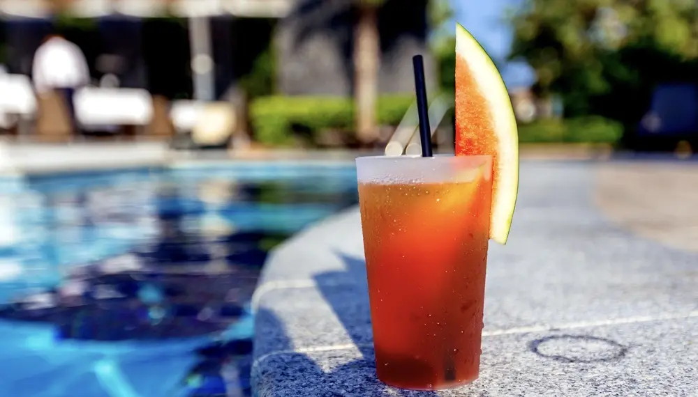 Cocktail on swimming pool ledge 
