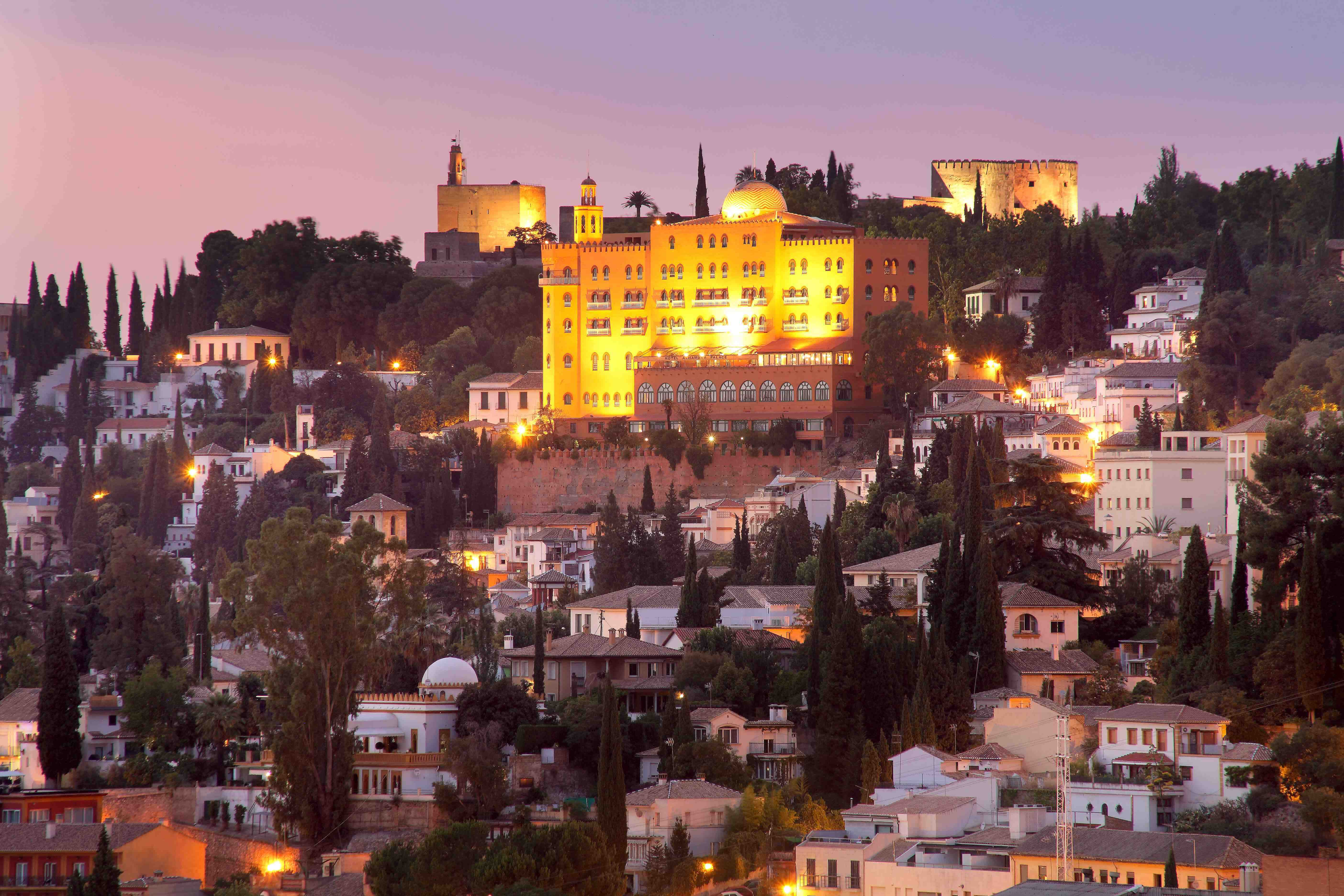 a far away photo of the hotel alhambra lit up at night