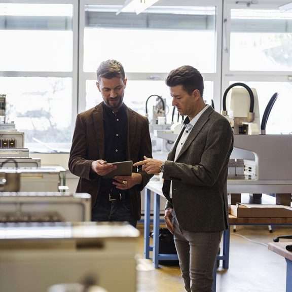 two workers looking at a device