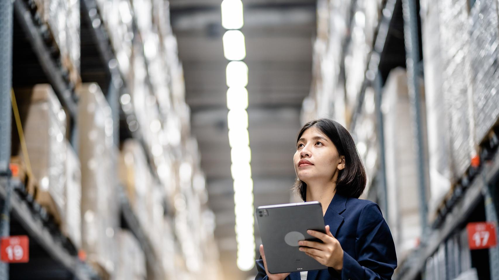 Manager accessing a document on a tablet in a warehouse 
