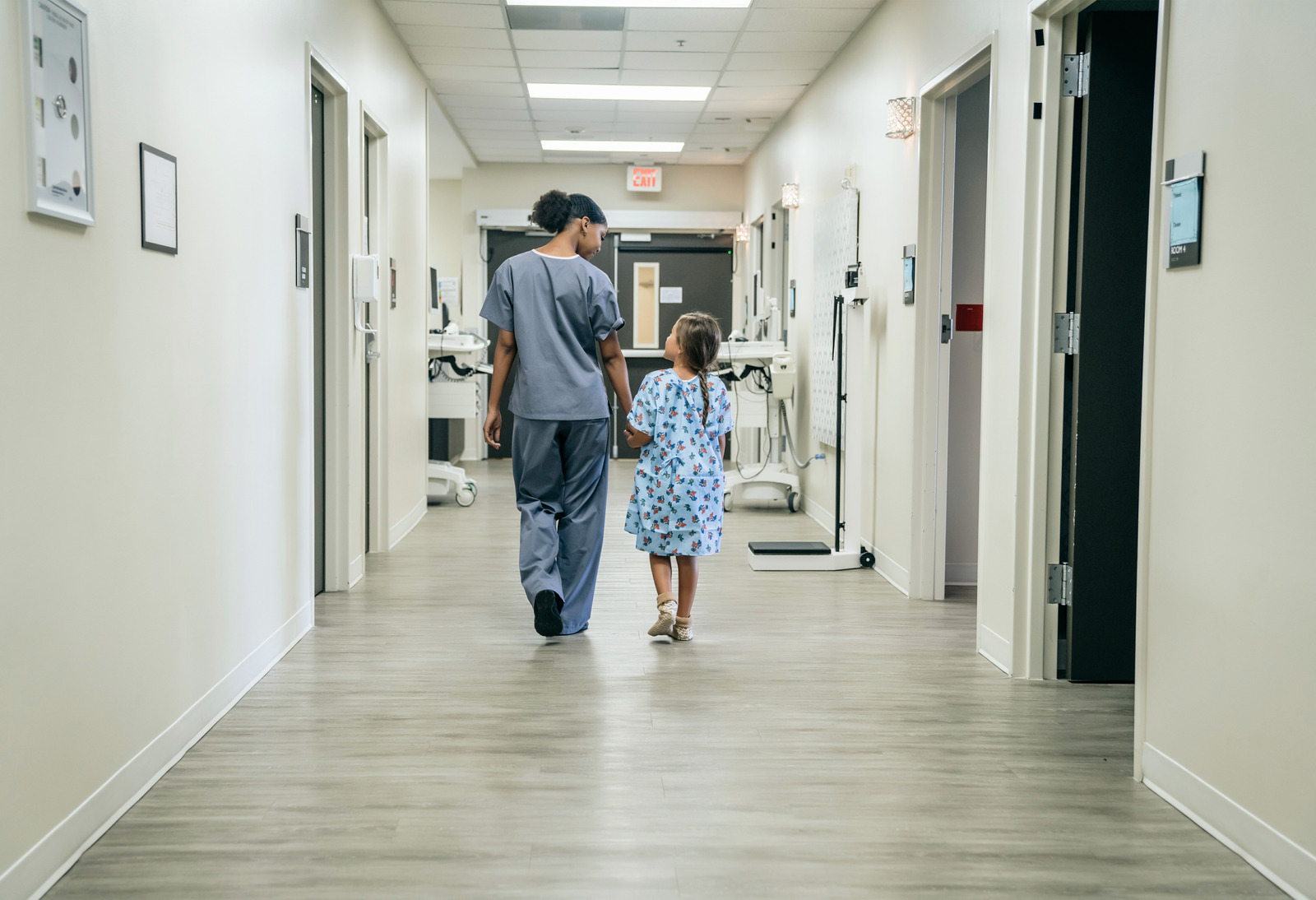 African American female nurse child patient hospital hallway