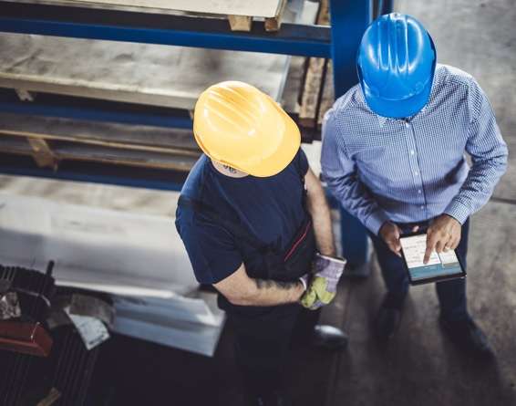 dos trabajadores de almacén mirando un dispositivo