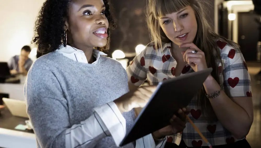 Two women working in the event management space utilizing a tablet to help with booking and billing in a restaurant