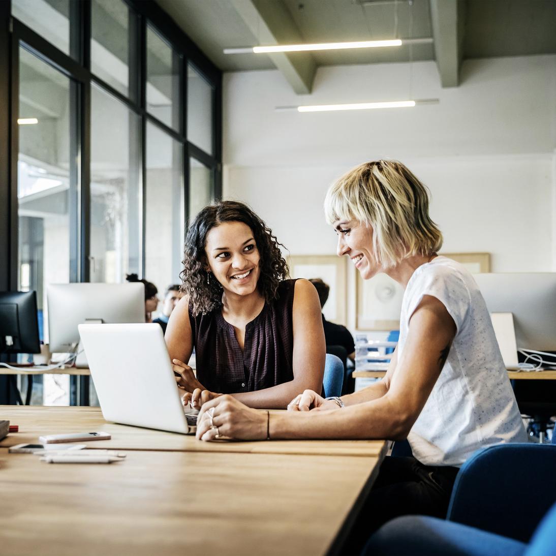 female colleagues smiling laptop germay
  office HR