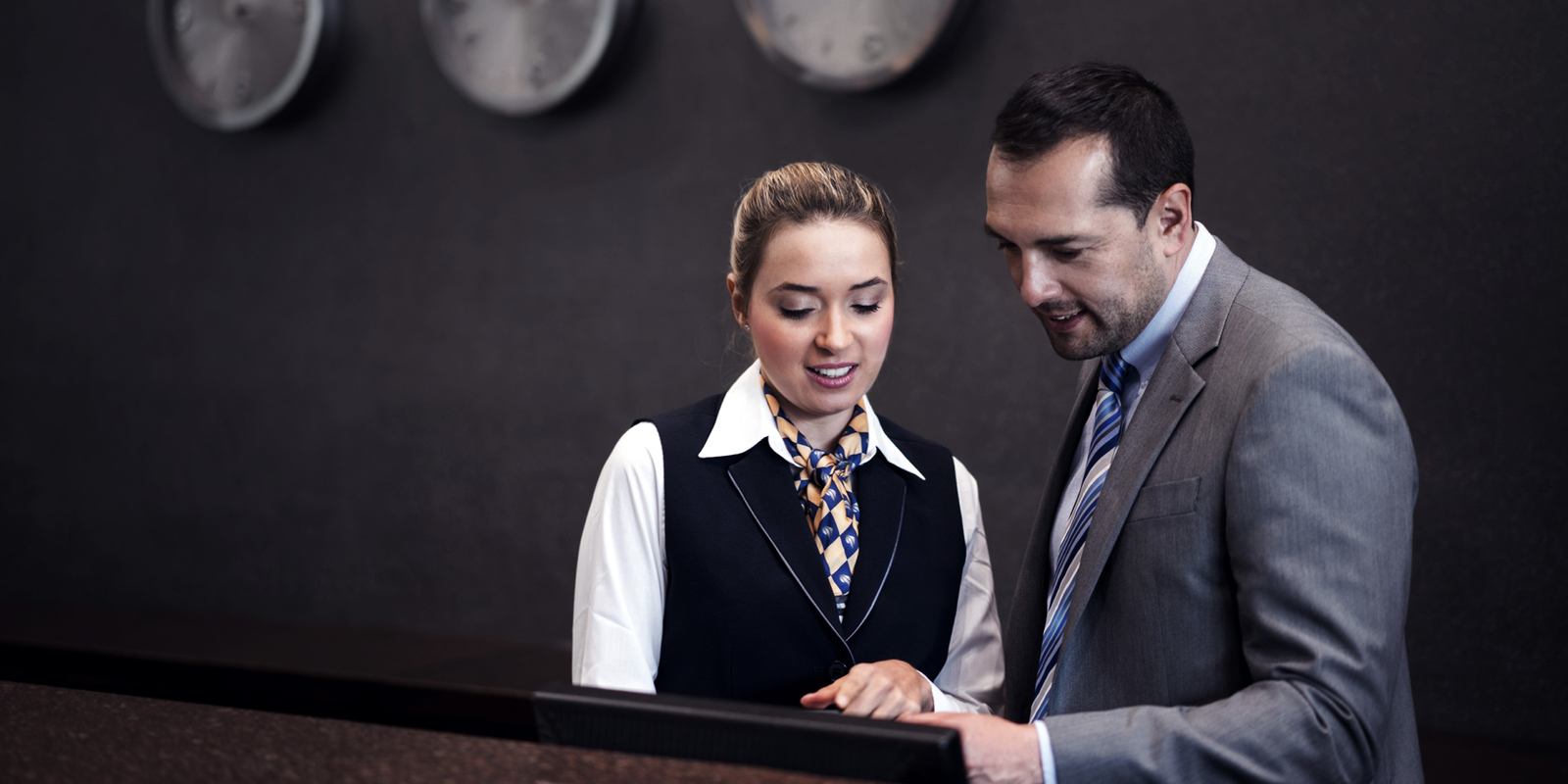 Hotel manager talking to woman at the front desk