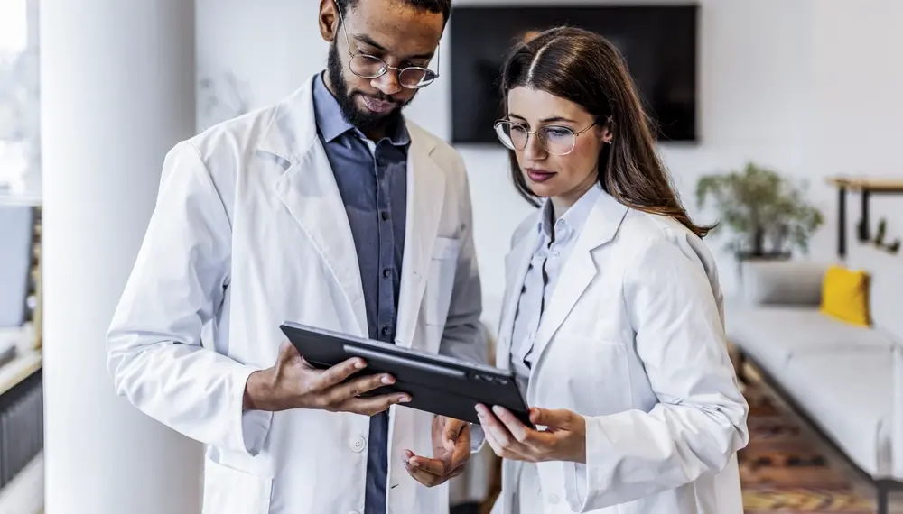 Medical researchers reviewing data on a tablet